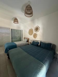 a bedroom with two beds and two clocks on the wall at DuMar Beachouse in Salema +49 photos