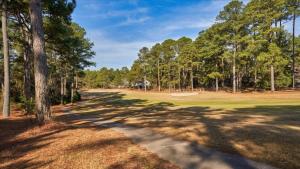 a golf course with trees and a dirt road at The Fox Hunt - A Ground Floor Condo in Southern Pines