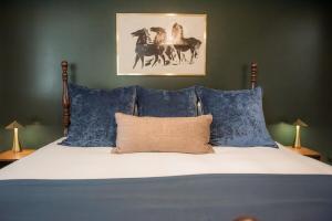 a bedroom with a bed with blue pillows at The Fox Hunt - A Ground Floor Condo in Southern Pines