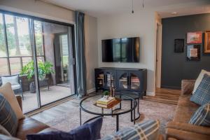 a living room with a fireplace and a tv at The Fox Hunt - A Ground Floor Condo in Southern Pines