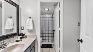 a white bathroom with a sink and a shower at The Fox Hunt - A Ground Floor Condo in Southern Pines +20 photos