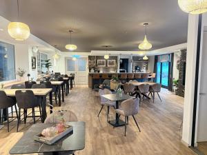a restaurant with tables and chairs and a bar at Eighty One Horse Boulevard in Valkenswaard