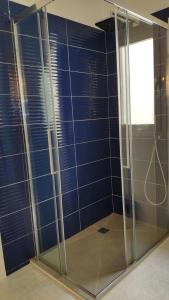 a glass shower with blue tiles in a room at Huéspedes Sa Font in Ibiza Town +15 photos