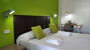 a bedroom with green walls and a bed with towels at Huéspedes Sa Font in Ibiza Town