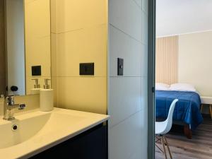 a bathroom with a sink and a bedroom with a bed at Studio Frente Al Muelle Barón in Valparaíso