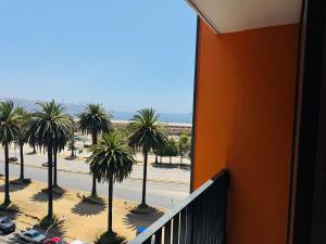 a balcony with a view of a street and palm trees at Studio Frente Al Muelle Barón in Valparaíso