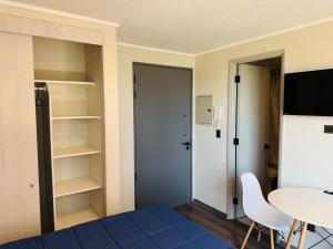 a room with a bed and a table and shelves at Studio Frente Al Muelle Barón in Valparaíso