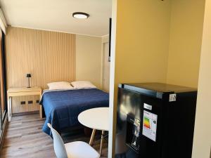 a small room with a bed and a small table at Studio Frente Al Muelle Barón in Valparaíso
