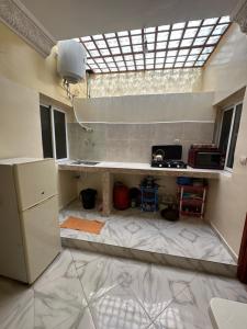 a room with a kitchen with a counter and a window at Apparemment tafoukt in Tafraout