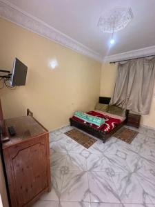 a small room with a bed and a television at Apparemment tafoukt in Tafraout