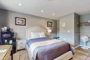 a bedroom with a bed and a desk and a tv at Sea Treasures Inn #101 in Rockaway Beach