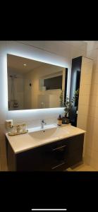 a bathroom with a sink and a large mirror at Aurora View Apartment - Free Parking & Walkable City Location in Tromsø