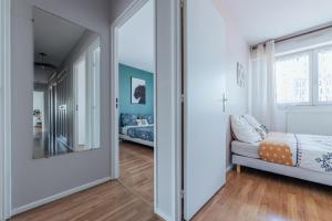 a hallway with a mirror and a bed in a room at Le Stanislas 61 - Spacieux & Cosy in Nancy