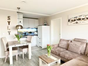 ein Wohnzimmer mit Sofa und Tisch in der Unterkunft Hotel Dünenburg in Westerland