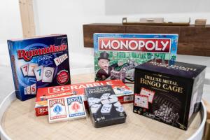 a table topped with boxes of monopoly and other games at Hollywood 4BR Home with Private Heated Pool in Hollywood +53 photos