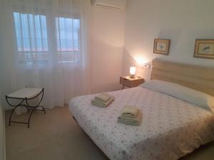 a bedroom with a bed with two towels on it at A 50 metros del mar y en 2 paradas de bus estas en el centro de Alicante in Alicante
