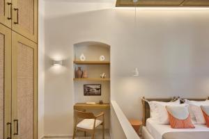 a bedroom with a bed and a desk with a chair at Alaia Boutique houses in Batsi
