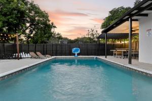 a swimming pool in a backyard with a table and chairs at Hollywood 4BR Home with Private Heated Pool in Hollywood