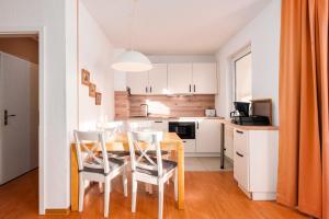 a kitchen with a table and chairs in a room at Strandhaus Lobbe, Sanddorn Nr 3 - Bade- & Saunawelt täglich inklusive in Lobbe