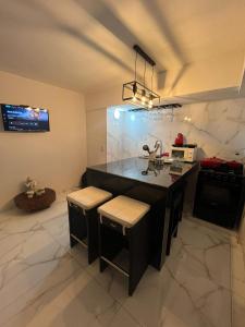 a kitchen with a island with stools and a tv at Vicco in Pinamar