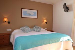 a bedroom with a bed with two pillows on it at Apartamento Complejo Pinimar in Port d'Addaia +10 photos