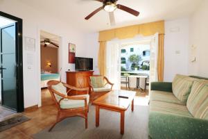 a living room with a couch and a table at Apartamento Complejo Pinimar in Port d'Addaia