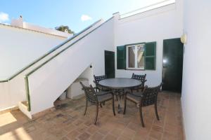a patio with a table and chairs and stairs at Apartamento Complejo Pinimar in Port d'Addaia