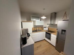 a kitchen with white appliances and wooden floors at L'Adret in Chorges