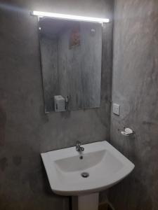 a bathroom with a white sink and a mirror at KADUPUL Hiriketiya in Hiriketiya