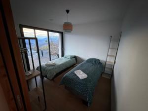 a small room with two beds and a window at L'Adret in Chorges
