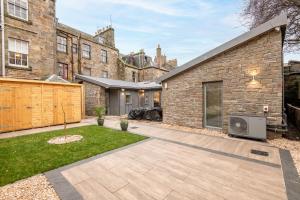a backyard of a brick building with a house at Rusheen Cottage in St. Andrews
