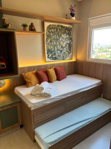 a bed in a small room with a window at Apê catedral centro in Goiânia +49 photos