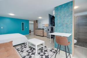 a room with a bed and a table and a kitchen at Leb'Den Executive Suites in Cali