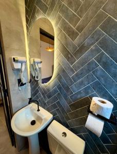 a bathroom with a sink and a toilet and a mirror at Onda Studios Apê Completo - Vista Linda e Sesc Bertioga - Ar Condicionado in Bertioga +33 photos