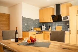 a kitchen with a wooden table with a bowl of fruit at Haus Pfeifenberger in Zederhaus