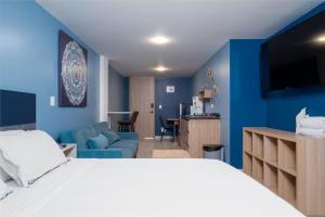 a bedroom with a white bed and a blue wall at Leb'Den Executive Suites in Cali