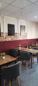 a dining room with tables and chairs and a chalkboard at Hôtel Le Poussin Rouge in Saint-Sauveur-sur-Tinée
