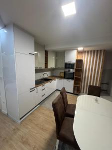 a kitchen with white cabinets and a table and chairs at Stan na dan Jelah in Jelah