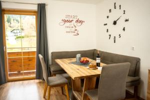 a dining room table with chairs and a clock on the wall at Haus Pfeifenberger in Zederhaus +101 photos