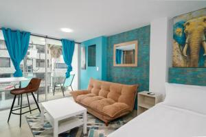 a living room with a couch and an elephant mural at Leb'Den Executive Suites in Cali