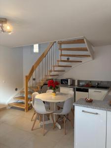 a kitchen with a table with chairs and a staircase at Maison cosy 64 m2 à 10 min de Strasbourg, idéale familles in Lampertheim