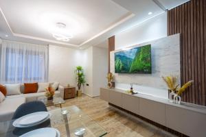 a living room with a couch and a tv on a wall at Magnificent apartment 10 in Casablanca