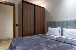 a bedroom with a large bed with a gray headboard at Magnificent apartment 10 in Casablanca
