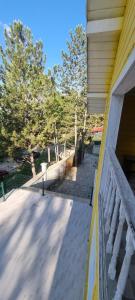 a porch of a house with a fence and trees at Özer hızarcıoglu in Talipler