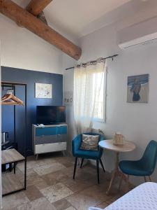 a room with a table and chairs and a tv at Maison d'hôtes Bastide St Victor à 2,5 kilomètres de Lourmarin in Puyvert +89 photos