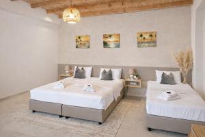 two beds in a room with white sheets at Secret Garden Hotel in Maleme +108 photos