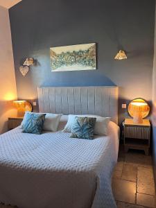 a bedroom with a large white bed with two lamps at Maison d'hôtes Bastide St Victor à 2,5 kilomètres de Lourmarin in Puyvert