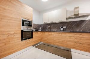 a kitchen with wooden cabinets and a stove top oven at Gzira Getaway in Il-Gżira