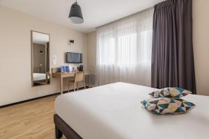 a hotel room with a bed and a window at Appart'City Confort Amiens Gare in Amiens