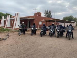 a group of people on motorcycles parked in front of a building at Hotel Corona del inca in Vinchina +5 photos